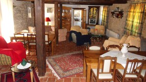 Ein gemütliches Wohnzimmer mit Kamin, Holzmöbeln und einem Fernseher.