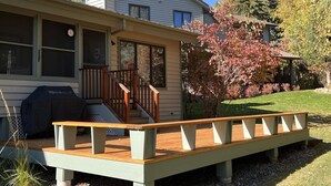 Et hus med overdækket terrasse, trappe og patio.