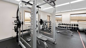 Ett gym med utrustning för styrketräning, hantlar och träningsbollar.