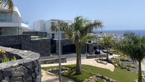 Een modern gebouw met een gevel van natuursteen en uitzicht op zee.