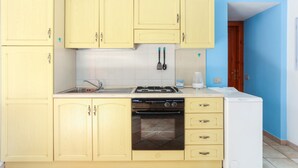 A kitchen with light yellow cabinets, a dishwasher, a stove, and a white refrigerator. - Holiday Apartment "Bilocale Geranium Beach" with Terrace & Air Conditioning (San teodoro)