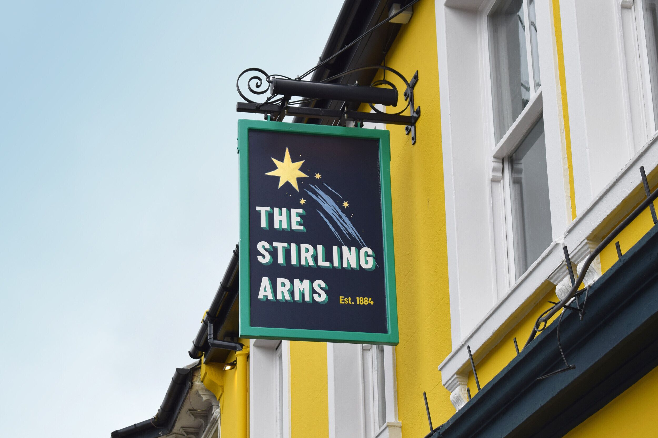A sign for 'The Stirling Arms' pub with a star and a starburst design.