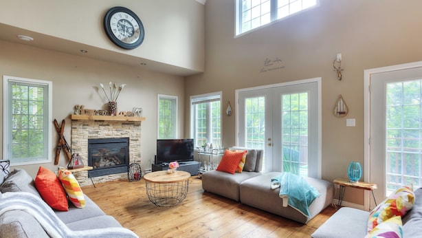 A spacious living room with a fireplace, comfortable seating, and large windows.