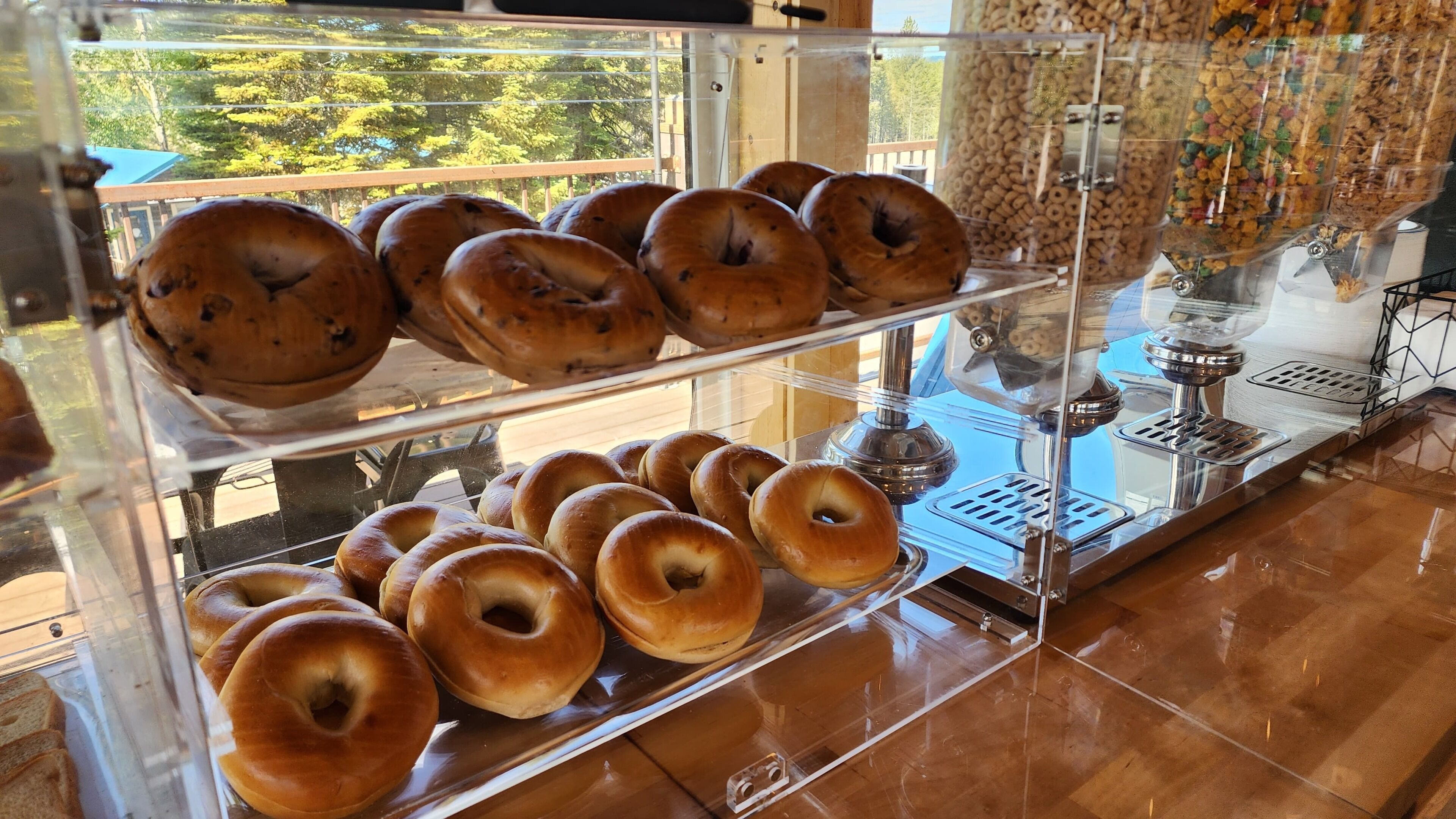 A bakery display case with bagels and a coffee machine.