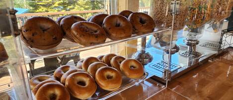 A bakery display case with bagels and a coffee machine.