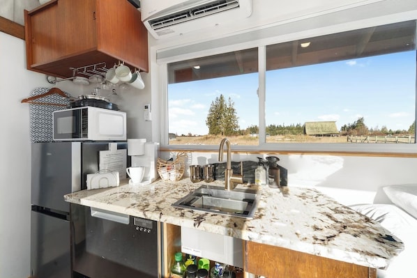 Cocina compacta con lavabo, microondas y refrigerador.