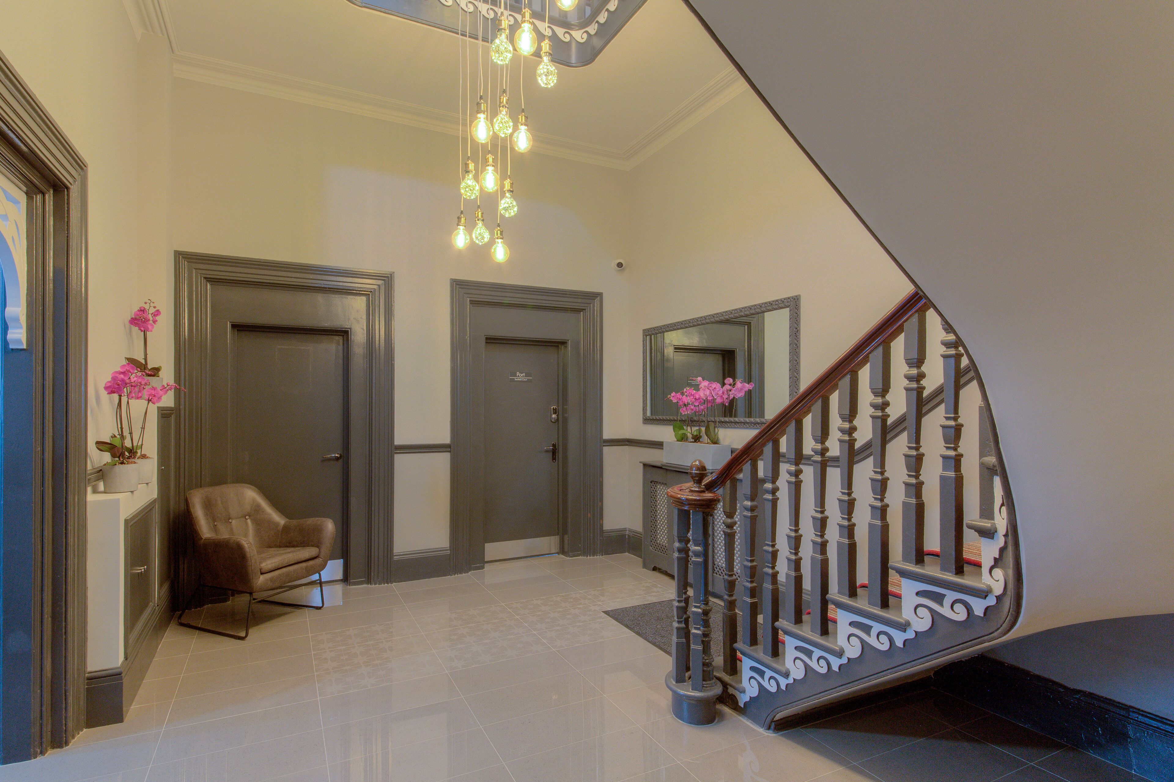Ein modernes Interieur mit Treppe, einem Sessel und einer Tür.