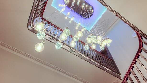 Una escalera con barandillas ornamentales y lámparas colgantes.