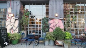 A bar and food establishment with outdoor seating, large windows, and a mural on the wall. - Chic Flat in Kentish Town, 5min to Hampstead Heath (London)