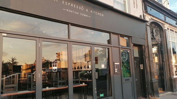 A modern café with large windows and outdoor seating. - Chic Flat in Kentish Town, 5min to Hampstead Heath (London)