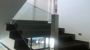 A modern staircase with glass railings leading to a landing. - Stunning villa, large private pool, 8' from beautiful beach (Quesada)