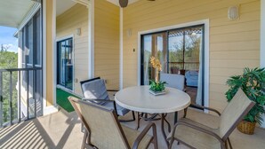 A covered patio with a ceiling fan, a round table with chairs, and a potted plant. - Caribe Cove -Gorgeous and Cozy   Close to Disney (Kissimmee)