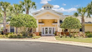 A Club House with a central entrance, surrounded by palm trees and well-maintained landscaping. - Caribe Cove -Gorgeous and Cozy   Close to Disney (Kissimmee)