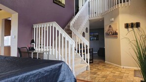 A bedroom with a bed, a staircase, and a dining area. - Cozy Colorado home with Serene views meant for pure relaxation! (Henderson)