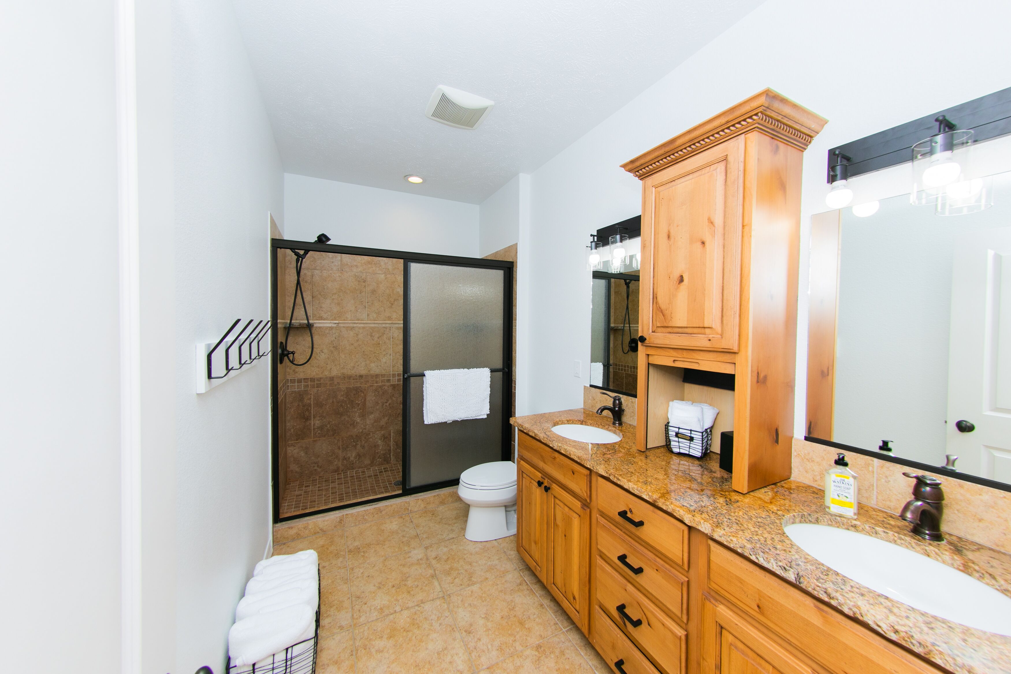 A modern bathroom with a shower, toilet, and vanity.