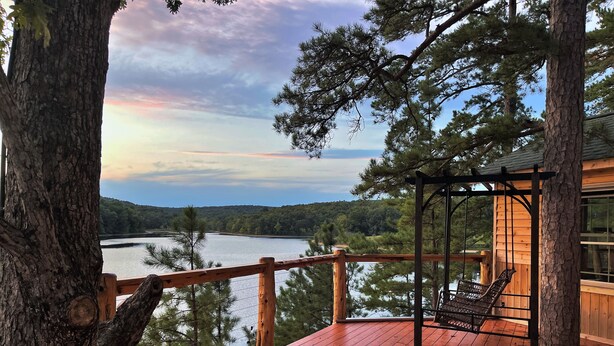 A wooden deck with a swing chair overlooking a lake. - 2-bedroom vacation home near Mark Twain National Forest (Potosi)