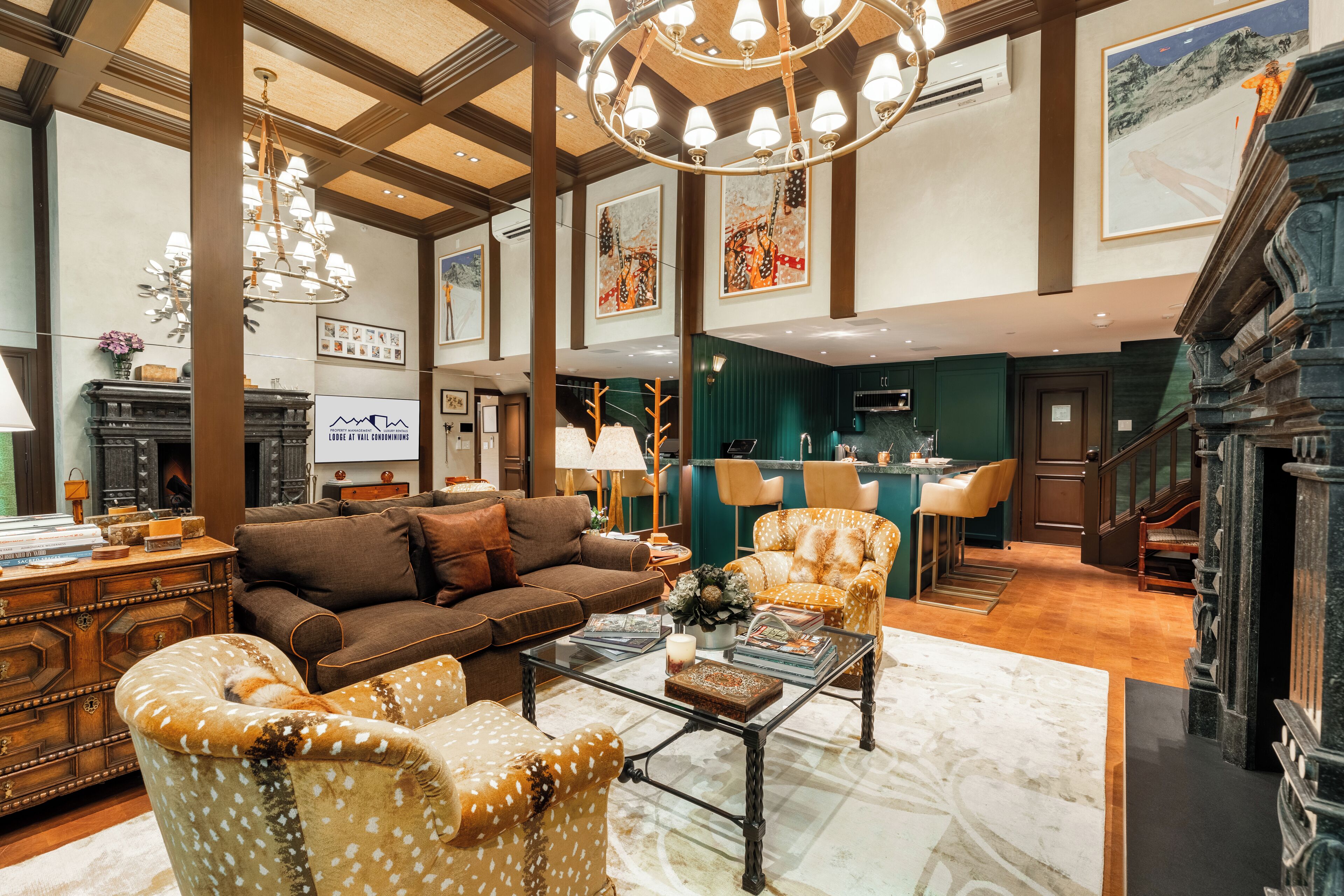 A spacious living room with a brown sofa, patterned armchairs, a coffee table, and a fireplace.