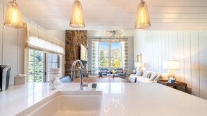 Una cocina moderna con una isla grande, una pared de acento de piedra y vistas al exterior.