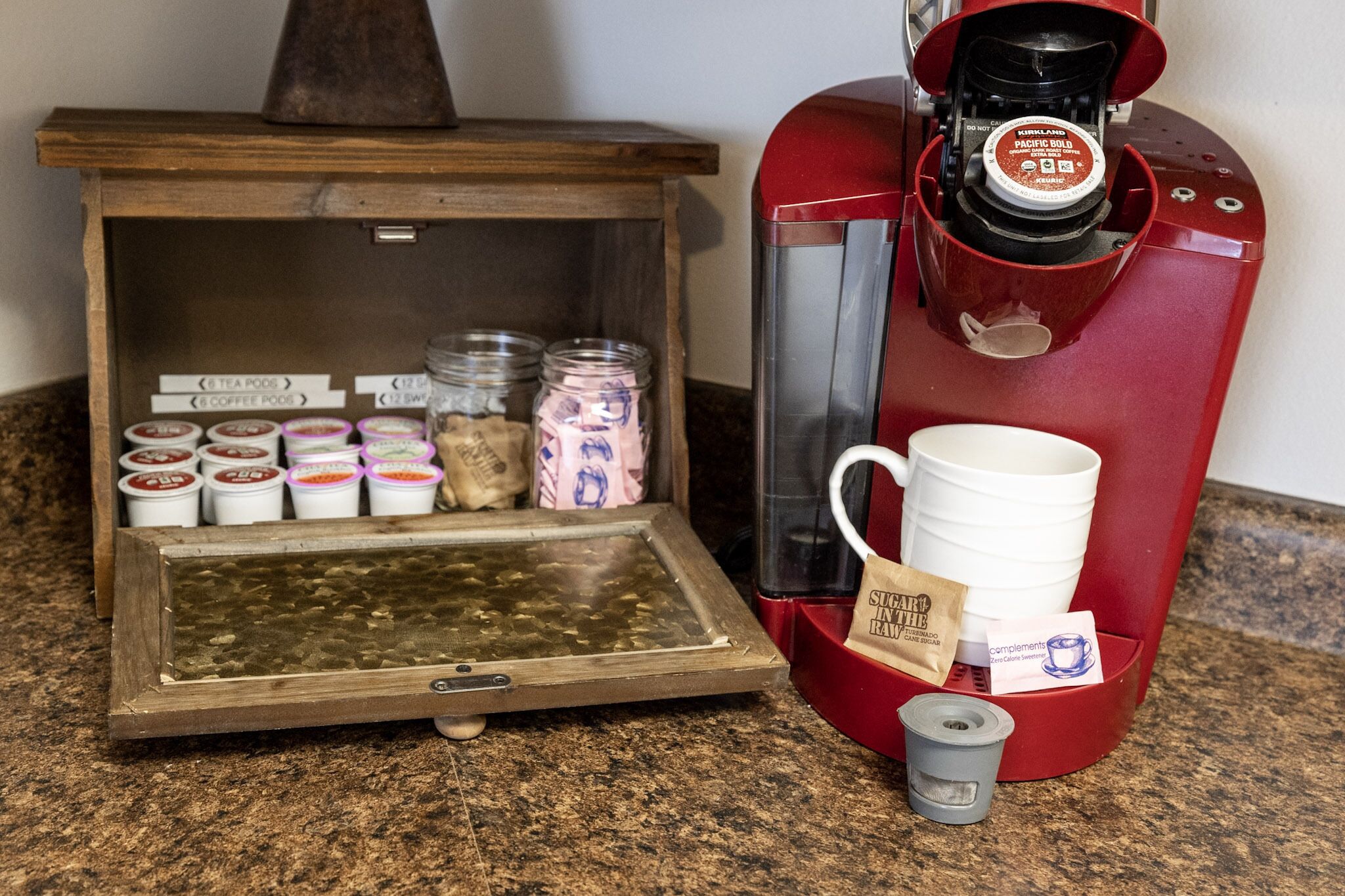 Une machine à café dotée d’un compartiment pour les capsules de café et d’une tasse.