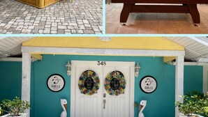 Een pooltafel, een bar met houten details en een exterieur in teal met het nummer 348 op de deur.