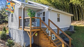 A single-story house with a wooden deck and stairs marked with the number 415. - 1/4 Mile to Ecusta Trail • Firepit • 1G Fiber Wi-Fi • Bamboo Bungalow (Hendersonville)