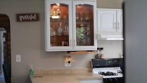 Une cuisine avec des meubles blancs, un plan de travail et une cuisinière.