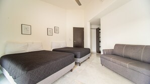A hotel room with two beds, a grey sofa, and a wardrobe. - Spacious House with Private Pool (Puerto Vallarta)