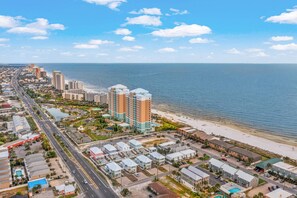 Paisagem costeira com um hotel na orla, uma avenida principal e edifícios residenciais.