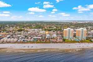 Uma cidade costeira com praia, edifícios residenciais e dois imponentes hotéis altos.