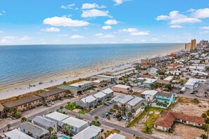 Uma cidade costeira com praia, edifícios residenciais e vista clara para o oceano.