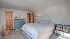 Ein Schlafzimmer mit Bett, Kommode und Nachttischen.