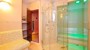 Une salle de bain moderne avec une douche à parois de verre, un banc et un sol carrelé.