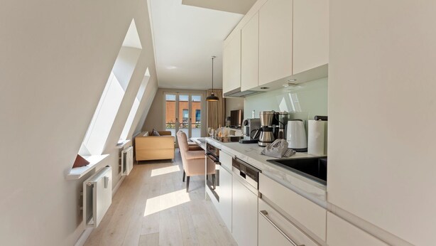 Una cocina moderna con comedor, ventanas amplias y vistas al exterior.