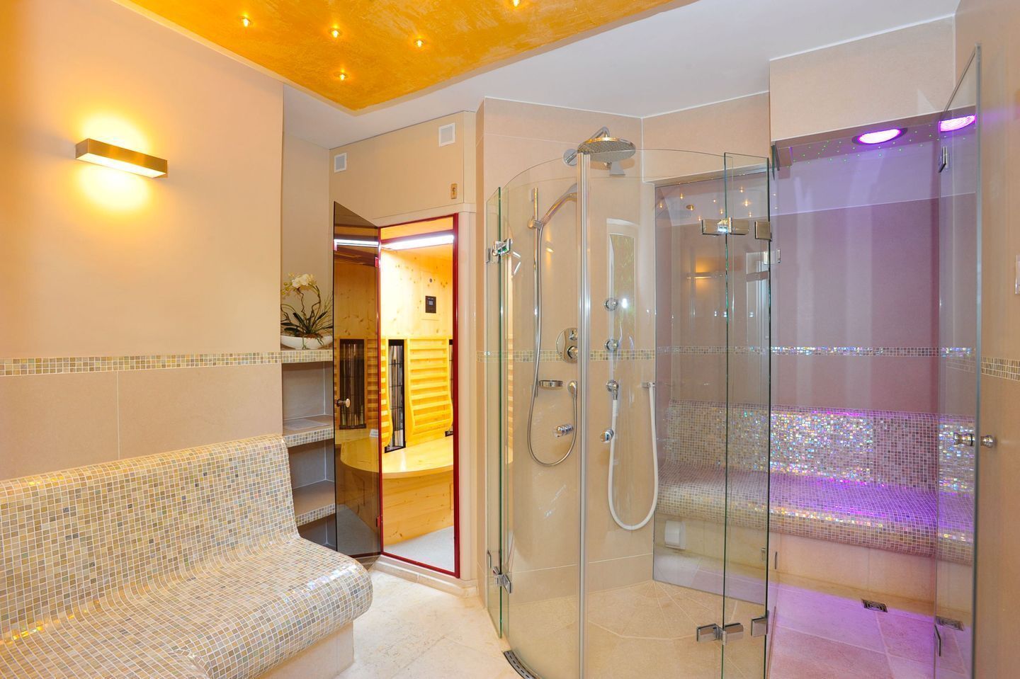 A modern bathroom with a glass-enclosed shower, a bench, and a vanity with a mirror.