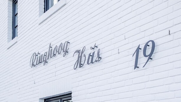 A building facade with the text "Ringhoog Huis 19" indicating a specific location or unit. - Komfortabel. Ruhig. Gemütlich. - Ringhoog Hüs Whg. 3 "wiesenblick" - Objekt-id: Rhh/03 - Ringhoog (Sylt)