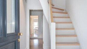 A modern interior with a staircase leading to an upper floor. - House Mühlenweg, Germany (Sylt)