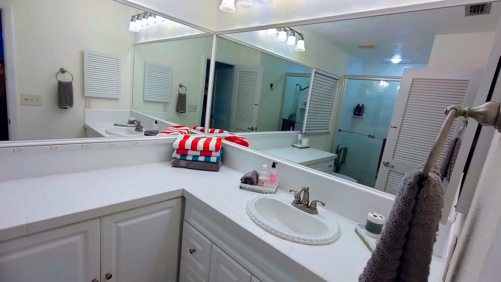 A bathroom with a white sink, a mirror, and a towel rack.