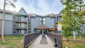 A multi-story building with a wooden deck leading to the entrance. - Silverthorne Condo: New Pool & Hot Tub + Fireplace (Silverthorne)