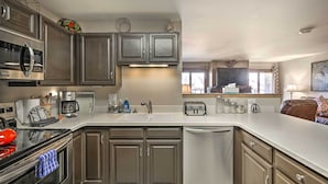 A modern kitchen with stainless steel appliances, a dishwasher, and a large island with a sink. - Silverthorne Condo: New Pool & Hot Tub + Fireplace (Silverthorne)