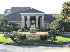 Un edificio con un letrero que dice "The Avalon", frente a una fuente y palmeras.