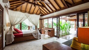 Una habitación con cama, escritorio y ventanas amplias.