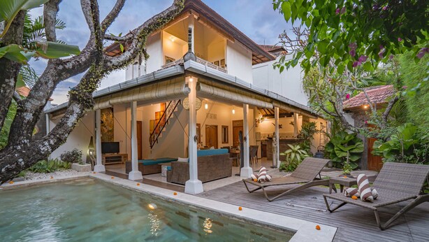 A two-story house with a swimming pool, outdoor seating, and a covered patio. - Villa Shanti (Seminyak)