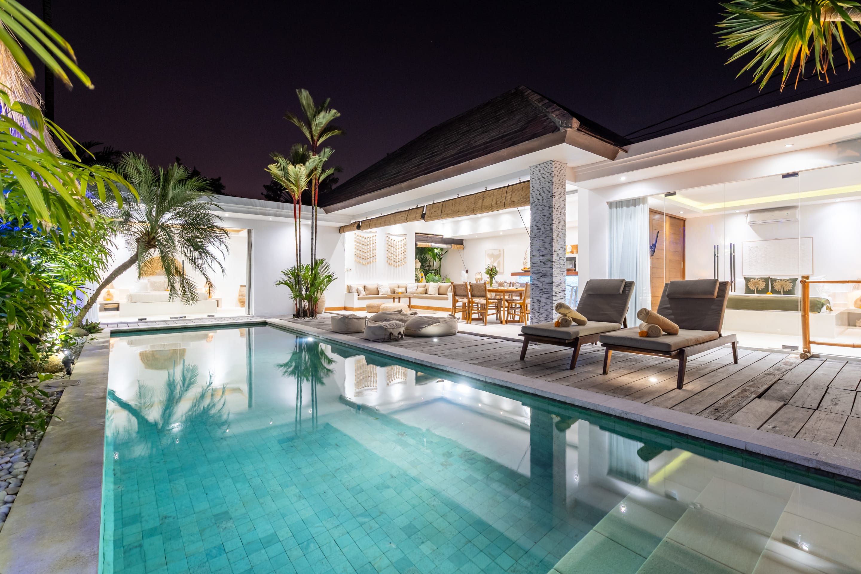 A poolside area with lounge chairs and a dining area.