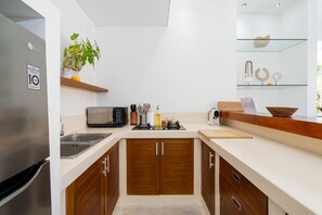 A modern kitchen with a built-in microwave, a coffee maker, and wooden cabinets.