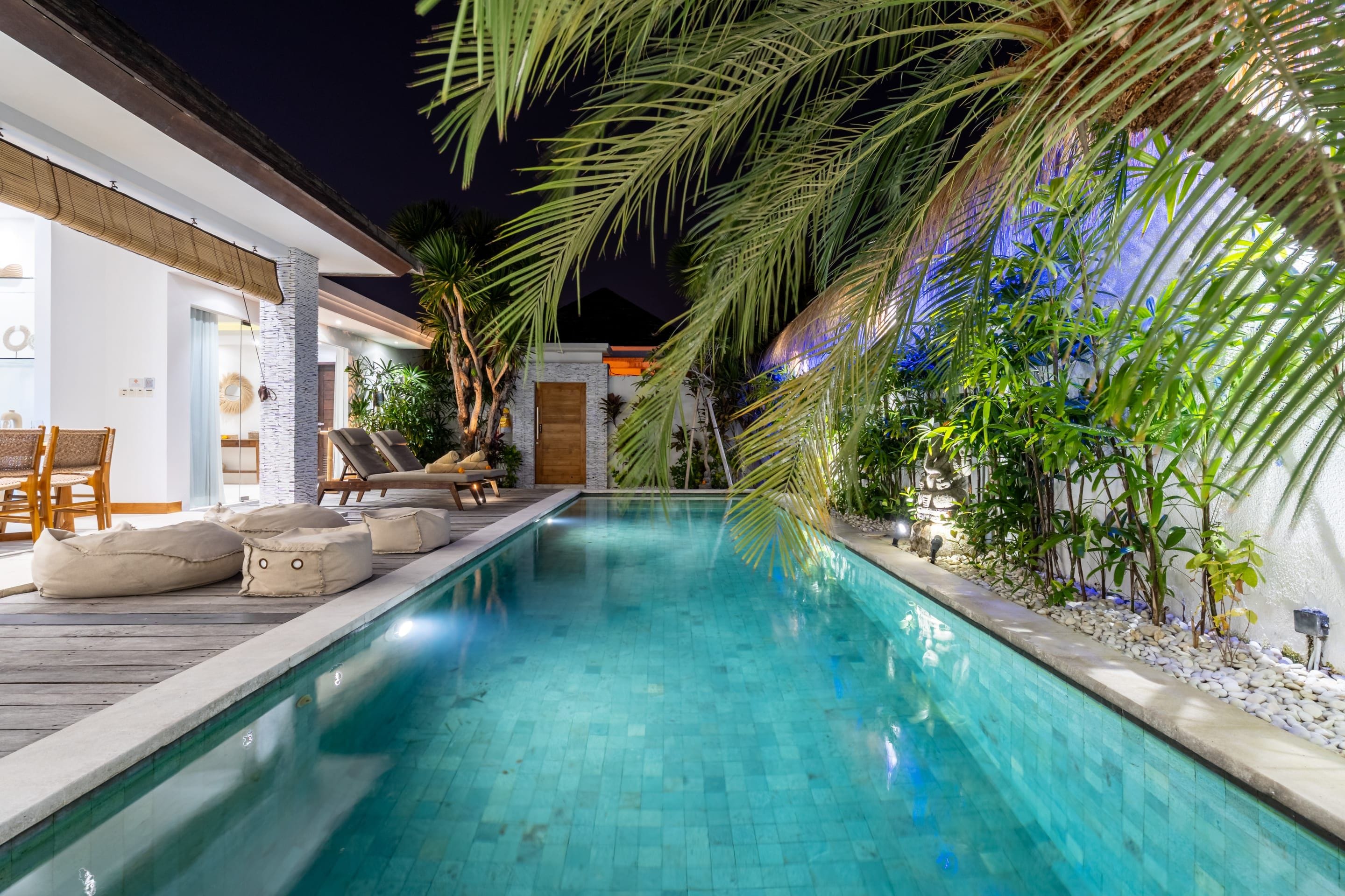 A swimming pool with lounge chairs and a wooden deck.