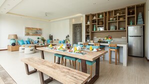 Una cocina moderna con una isla de madera, estanterías empotradas y un refrigerador de acero inoxidable.