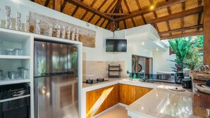 A modern kitchen with stainless steel appliances, wooden cabinets, and a large island. - Villa Marula (Seminyak)