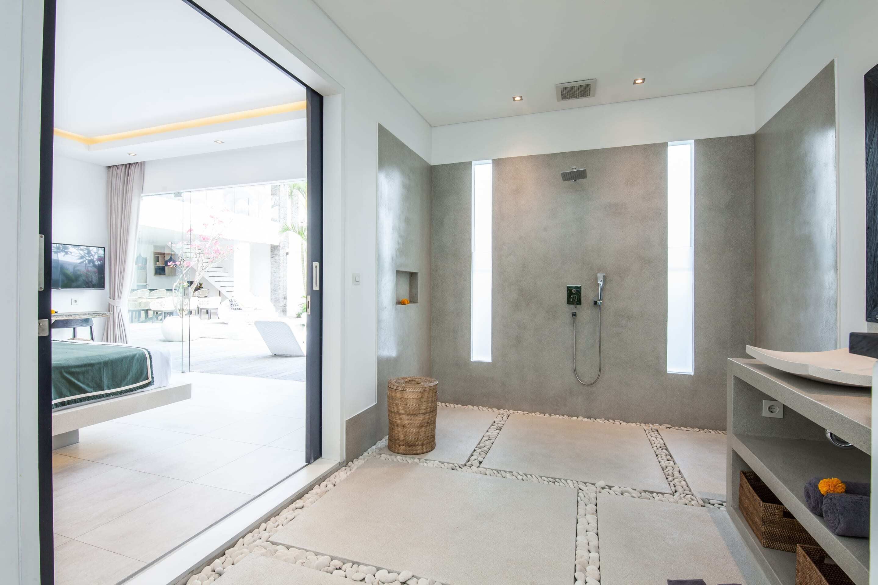 Un baño moderno con una ducha amplia, tocador y vistas al exterior.