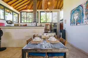 Enjoy meals in this cozy dining area with a rustic table, comfortable chairs, and a beautiful view of the surrounding greenery.