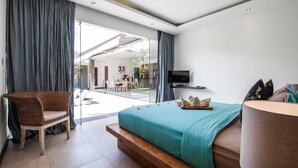Un dormitorio moderno con una cama grande, una silla de mimbre, un televisor y vistas al exterior.